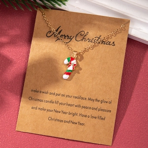 Detail of Christmas candy cane necklace with colorful enamel on a kraft paper wish card