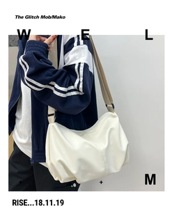 Detail of white minimalist dumpling bag with pleated texture and adjustable wide strap