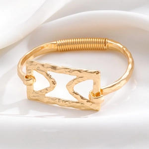 Detailed macro view of gold plated hammered texture bracelet with geometric cutouts
