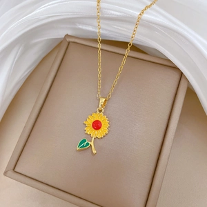 Gros plan détaillé du pendentif tournesol doré avec émail jaune sur un écrin à bijoux