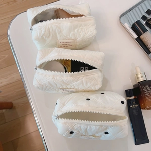 Trois trousses à maquillage matelassées avec dentelle, losanges et motifs à pois noirs