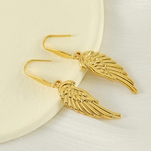 Close-up of gold wing-shaped drop earrings featuring detailed feather textures on silk