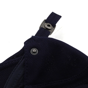 Detail of navy mesh fabric with dark grey metal snap button and adjustable buckle