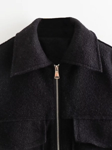 Close-up of classic lapel and silver metal zipper on black wool coat fabric
