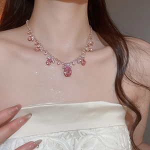 Gros plan d'un collier avec pendentif goutte en zircon rose et chaîne sertie de diamants