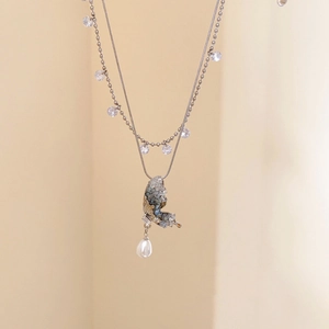 Detail of a layered butterfly necklace with teardrop pearl and clear crystals
