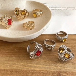 Close-up of vintage resin heart rings with hammered metal texture and colorful gems