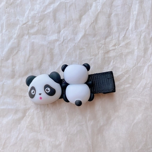 Detailaufnahme einer süßen schwarz-weißen Panda-Haarklammer für Mädchen auf Papier