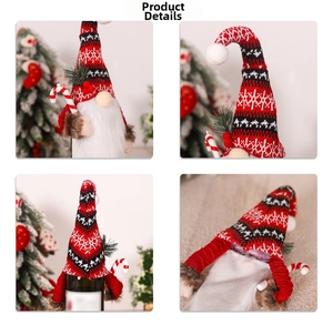 Detail showing knitted Christmas gnome wine bottle cover with candy cane and long white beard