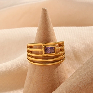 Détail macro d'une bague multicouche plaquée or 18 carats avec un zircon violet rectangulaire