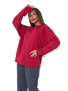 Detail shot of a red oversized crewneck sweatshirt featuring soft cotton fleece texture