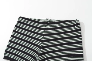 Detailed macro view of high-quality knit texture on green and black striped shorts