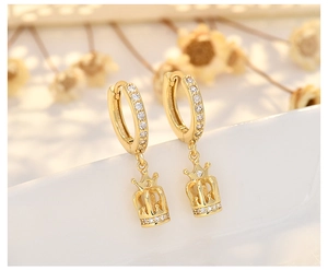 Detailed shot of gold crown earrings featuring sparkling white zircon accents and hoops