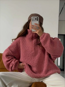 Close-up of pink sherpa fleece texture and half-zip high collar detail on cozy pullover