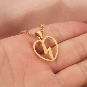 Collier doré en acier inoxydable avec pendentif cœur et éclair posé sur une main