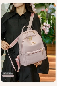 Detailed view of dusty rose PU leather backpack with gold kangaroo logo on a model