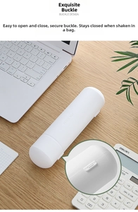 Detail view of white cylindrical pencil case with secure snap closure on a wooden desk