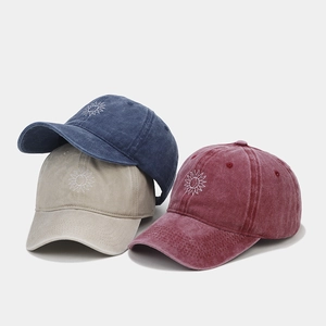 Détail de trois casquettes de baseball en coton délavé avec motif de soleil brodé