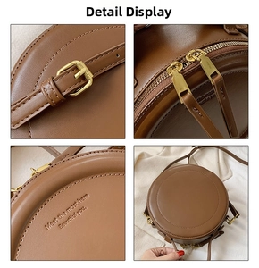 Dettaglio della borsa circolare marrone vintage con hardware oro e scritte a rilievo