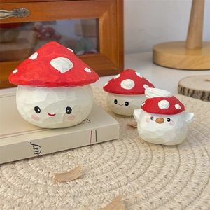Close-up of three cute handcrafted mushroom figurines with expressive faces on a woven mat
