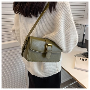Detail of vintage olive green wax leather shoulder bag with golden metallic buckle