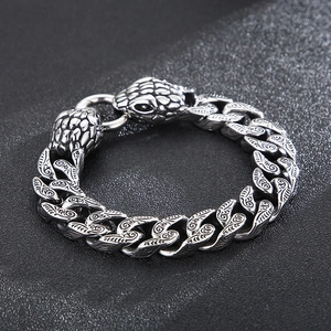 Macro detail of punk style double snake head Cuban link bracelet in vintage steel