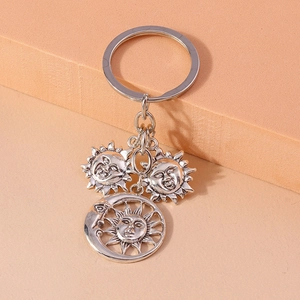 Detailed view of silver celestial keychain featuring sun and crescent moon charms