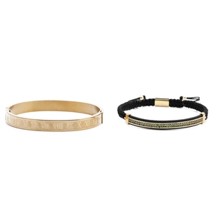 Detail of gold roman numeral cuff and black braided bracelet with green zircon bar