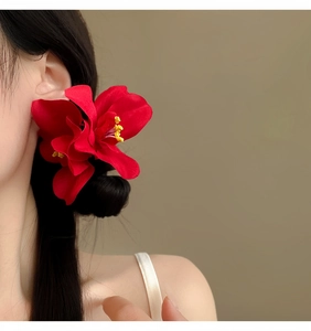 Primer plano detallado de pinzas para el cabello de flores de orquídea roja vibrante