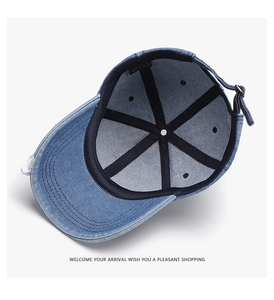 Detail of blue washed denim baseball cap showing 100% cotton label and internal structure