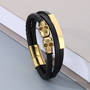 Detail of multilayer black leather bracelet with golden skull beads and magnetic clasp