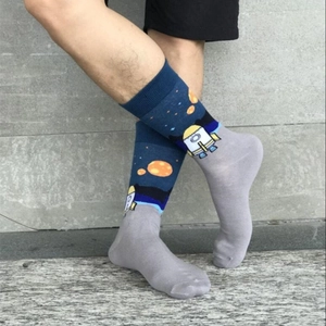 Navy blue cotton mid-calf socks with astronaut and rocket pattern on a male model