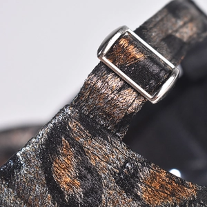 Macro detail of adjustable silver buckle and leopard pattern jacquard strap on baseball cap