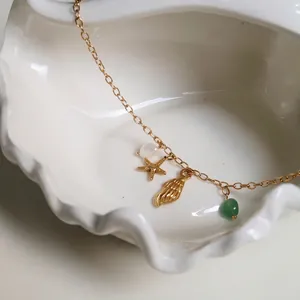Macro detail of ocean theme necklace with starfish shell and pearl charms