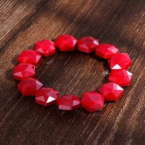 Detailed view of bohemian red faceted crystal beads and agates on an elastic bracelet