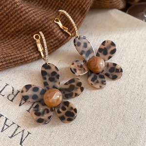 Close-up of leopard print acetate flower earrings with gold-plated rhinestone hooks