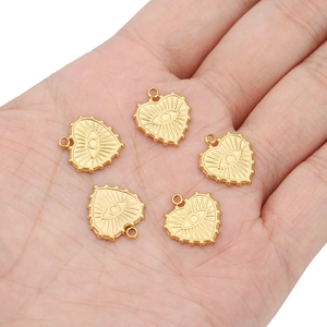Five gold heart-shaped Evil Eye charms in 18k plated stainless steel held in hand