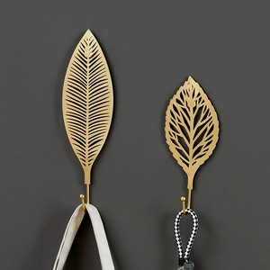 Nordic leaf shaped metal wall hooks in gold finish with decorative hanging bags