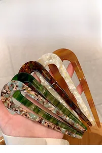 U-shaped hair pins set in amber and leopard patterns shown in hand for detail