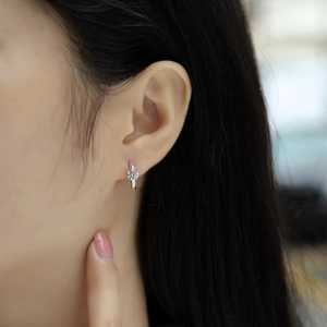 Close-up of a model wearing minimalist silver hoop earrings with double-row sparkling stones