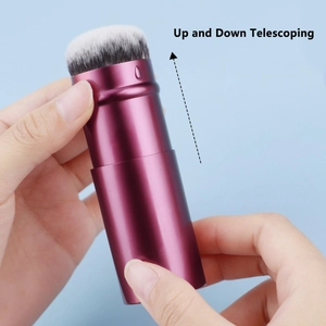 Detail showing the up and down telescoping function of the purple travel makeup brush