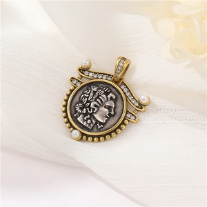 Macro shot of retro Greek relief pendant with gold frame, pearls, and crystal details