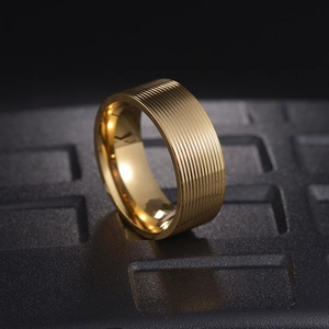Macro detail of 8mm gold titanium men's ring featuring grooved textures and polished edges
