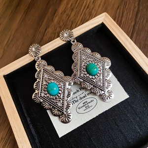 Detailed view of silver bohemian drop earrings with turquoise stones and rhinestone accents