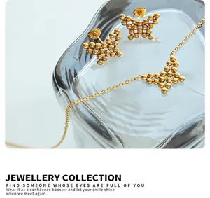 Macro shot of gold butterfly jewelry set including stud earrings and a beaded chain necklace