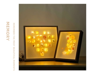 Macro detail of DIY shell shadow box frames with warm LED lighting on a wood table