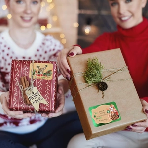 Détail d'étiquettes de Noël avec motifs de renne et bougie sur des boîtes cadeaux