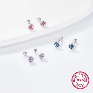 Macro detail of 925 silver flower barbell earrings with pink, blue and purple zircon