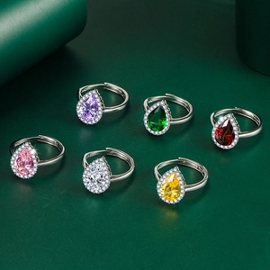 Macro view of pear-cut emerald and colorful gemstone rings with S925 silver stamp detail