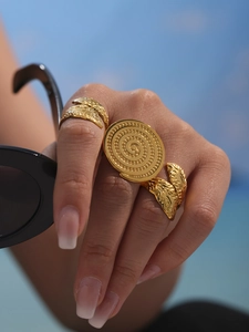 Macro detail of three-piece gold leaf rings set with intricate bohemian textures